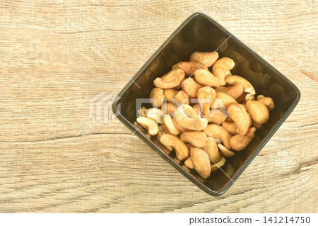 roasted salty cashew nuts arranging in black square cup on table roasted salty cashew nuts arranging in black square cup on table 141214750