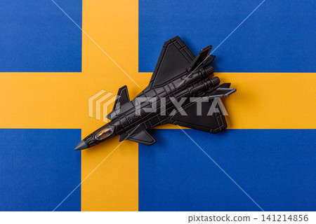 A fighter jet against the Swedish flag as a conceptual background representing defense A fighter jet against the Swedish flag as a conceptual background representing defense 141214856
