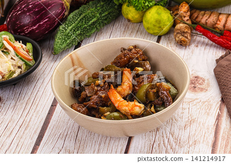 Bowl of stir fried shrimp and eggplant with fresh vegetables on wooden table Bowl of stir fried shrimp and eggplant with fresh vegetables on wooden table 141214917