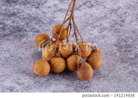Fresh longan fruit cluster on textured gray background Fresh longan fruit cluster on textured gray background 141214936