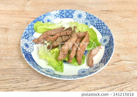 fried crispy salty fermenting beef fat meat with pepper topping lettuce salad on plate fried crispy salty fermenting beef fat meat with pepper topping lettuce salad on plate 141215018