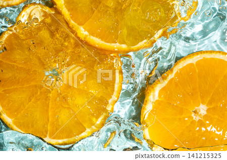 Top view of fresh orange slices submerged in clear rippling water 141215325