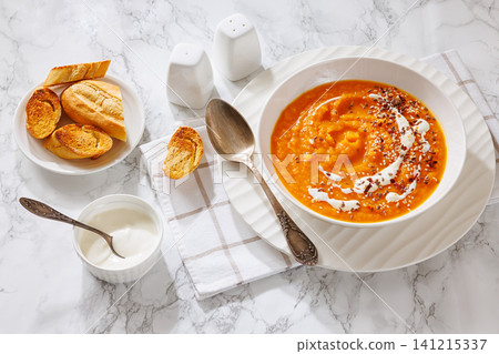 spiced sweet potato soup in a white bowl 141215337