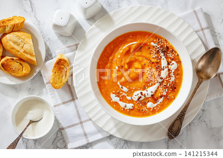 spiced sweet potato soup in a white bowl spiced sweet potato soup in a white bowl 141215344