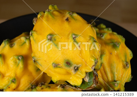 Group of whole raw exotic yellow pitahaya dragon fruits Group of whole raw exotic yellow pitahaya dragon fruits 141215389