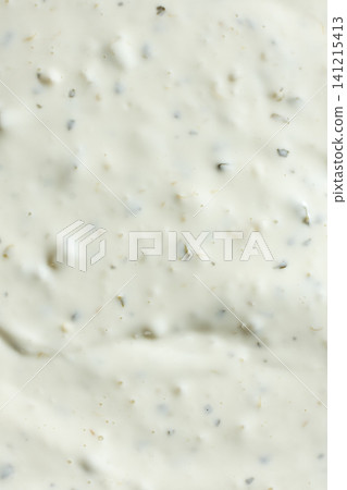 White garlic sauce background with flecks of spices White garlic sauce background with flecks of spices 141215413