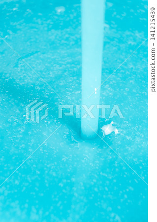 Thick blue soap pouring into a container, concept of laundry or manufacturing Thick blue soap pouring into a container, concept of laundry or manufacturing 141215439