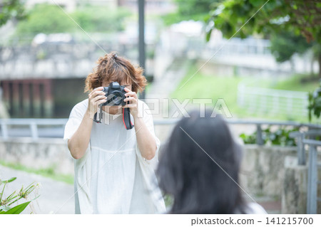 The daily life of a middle-aged woman who enjoys photography as a hobby in the park. 141215700