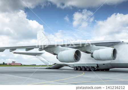 Unloading a white big heavy transport aircraft. The rear cargo compartment is open Unloading a white big heavy transport aircraft. The rear cargo compartment is open 141216212