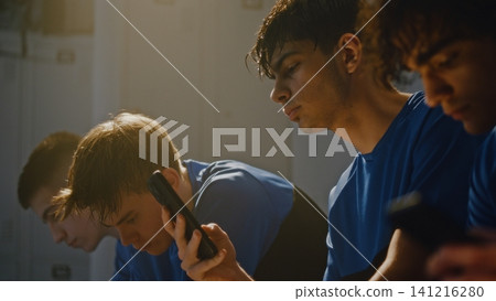 Youth Athletes Using Mobile Phones in Dressing Room Before Practice Youth Athletes Using Mobile Phones in Dressing Room Before Practice 141216280