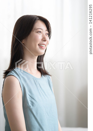 Profile of a Japanese woman relaxing in her room Profile of a Japanese woman relaxing in her room 141216295