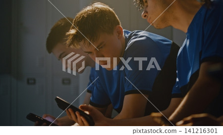 Teenage Soccer Players Sharing Media on Smartphone in Locker Room Teenage Soccer Players Sharing Media on Smartphone in Locker Room 141216301