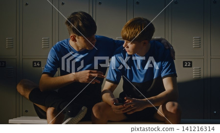 Two Teenage Footballers Talking in Modern Locker Room Two Teenage Footballers Talking in Modern Locker Room 141216314