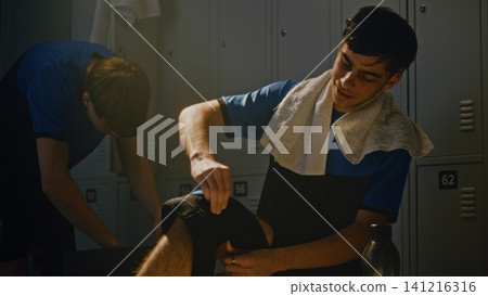 Teen Athlete Adjusting Knee Support Brace Before Training Session Teen Athlete Adjusting Knee Support Brace Before Training Session 141216316