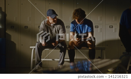 Youth Football Team Locker Room with Coach and Disappointed Player Youth Football Team Locker Room with Coach and Disappointed Player 141216321