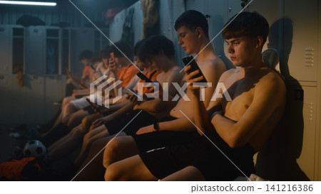 Teenage Football Teammates Taking Well Earned Break after Practice inside Locker Room Teenage Football Teammates Taking Well Earned Break after Practice inside Locker Room 141216386