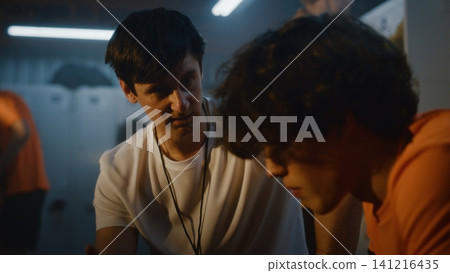 In Soccer Locker Room, Coach Offers Constructive Feedback and Encouragement to Young Boy In Soccer Locker Room, Coach Offers Constructive Feedback and Encouragement to Young Boy 141216435