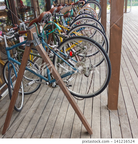 A bicycle parked in a cafe's cycle stand, a scene of cycling. A bicycle parked in a cafe's cycle stand, a scene of cycling. 141216524