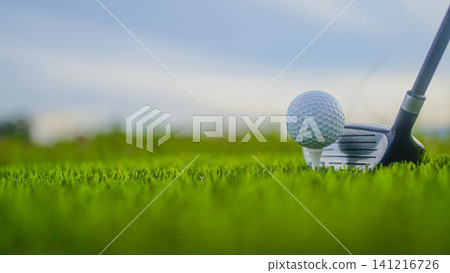 Golf clubs and balls on a green lawn in a beautiful golf course with morning sunshine. Golf clubs and balls on a green lawn in a beautiful golf course with morning sunshine. 141216726