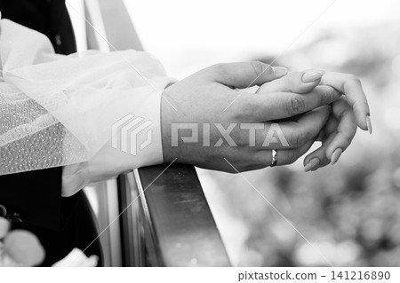 Couple holding hands on balcony with wedding ring in black and white close up. Couple holding hands on balcony with wedding ring in black and white close up. 141216890