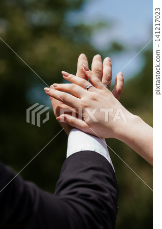 Close up of bridal couple hands with wedding ring held against blurred green nature background. Close up of bridal couple hands with wedding ring held against blurred green nature background. 141217023