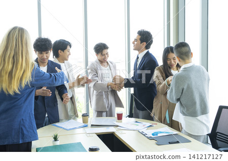 Happy multiracial business team giving high fives gesture, celebrating success. Achievement mission at company. Happy multiracial business team giving high fives gesture, celebrating success. Achievement mission at company. 141217127