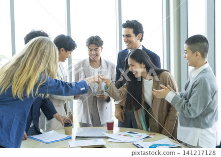 Happy multiracial business team giving high fives gesture, celebrating success. Achievement mission at company. Happy multiracial business team giving high fives gesture, celebrating success. Achievement mission at company. 141217128