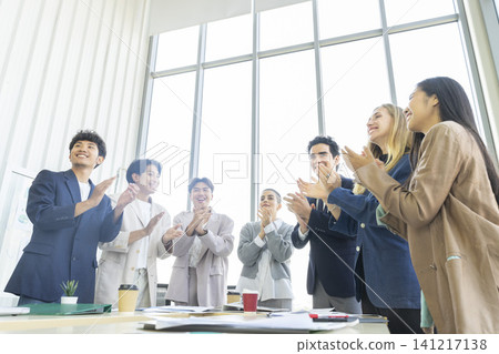 Happy multiracial business team giving high fives gesture, celebrating success. Achievement mission at company. Happy multiracial business team giving high fives gesture, celebrating success. Achievement mission at company. 141217138