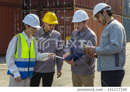 Group of engineers working and inspecting freight order in the container yard. This is a freight transportation and distribution warehouse. Group of engineers working and inspecting freight order in the container yard. This is a freight transportation and distribution warehouse. 141217199