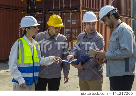 Group of engineers working and inspecting freight order in the container yard. This is a freight transportation and distribution warehouse. 141217200
