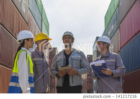 Group of engineers working and inspecting freight order in the container yard. This is a freight transportation and distribution warehouse. Group of engineers working and inspecting freight order in the container yard. This is a freight transportation and distribution warehouse. 141217216