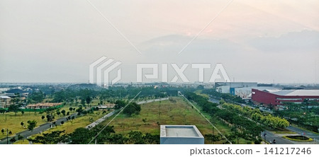View of an urban area and a green field at dusk View of an urban area and a green field at dusk 141217246