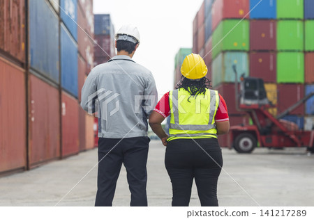 African American female and Latino male worker using tablet, checking workflow loading freight containers from Cargo freight, import export concept. 141217289