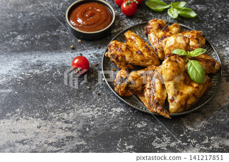 Barbecue chicken wings with sauce on a stone surface. Traditional baked bbq buffalo. Tasty snack for beer. Copy space. Barbecue chicken wings with sauce on a stone surface. Traditional baked bbq buffalo. Tasty snack for beer. Copy space. 141217851