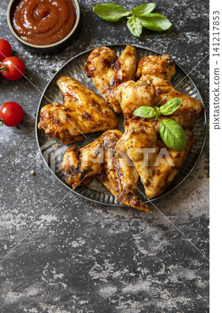 Barbecue chicken wings with sauce on a stone surface. Traditional baked bbq buffalo. Tasty snack for beer. Copy space. 141217853