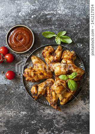 Barbecue chicken wings with sauce on a stone surface. Traditional baked bbq buffalo. Tasty snack for beer. Top view flat lay background. 141217854