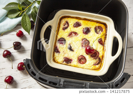 Homemade cottage cheese casserole with cherries in kitchen gadget modern air fryer on wooden background. perfect for breakfast or a snack. 141217875