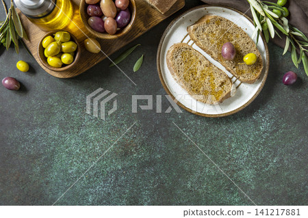 Italian ciabatta bread with olive oil on a stone surface. Delicious and healthy food. Vegan. Top view flat lay background. Copy space. 141217881