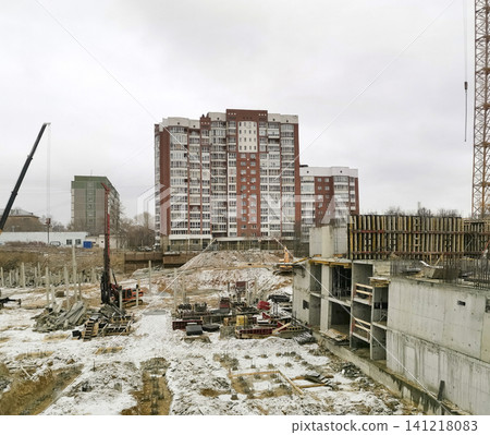 Construction site with building foundation and residential buildings in background Construction site with building foundation and residential buildings in background 141218083