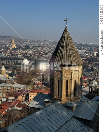 Ancient church tower with cross overlooking cityscape of Tbilisi, Georgia. Ancient church tower with cross overlooking cityscape of Tbilisi, Georgia. 141218103