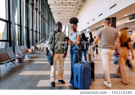 Young couple checking mobile phone at modern airport terminal 141218180