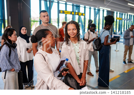 Diverse people waiting in line at modern airport terminal Diverse people waiting in line at modern airport terminal 141218185