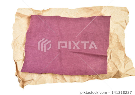 A crumpled piece of brown craft paper with a piece of fabric. 141218227