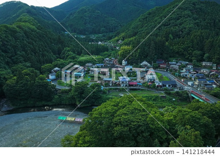 一張從傾斜角度拍攝的空拍照片,顯示了東京秋川谷沿岸的一個山村。 一張從傾斜角度拍攝的空拍照片,顯示了東京秋川谷沿岸的一個山村。 141218444