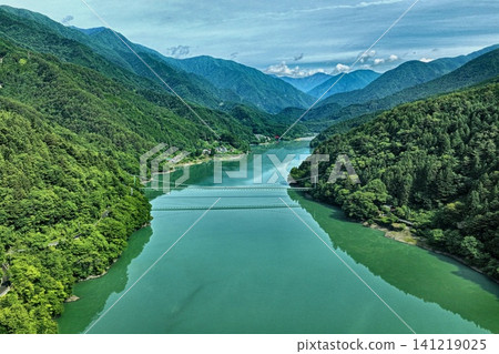 An aerial photograph overlooking Lake Ikawa and its suspension bridge in Shizuoka Prefecture. An aerial photograph overlooking Lake Ikawa and its suspension bridge in Shizuoka Prefecture. 141219025