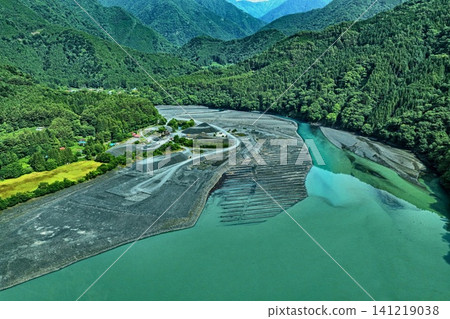 An aerial photograph capturing the exposed riverbed and blue-green surface of Lake Ikawa in Shizuoka Prefecture. An aerial photograph capturing the exposed riverbed and blue-green surface of Lake Ikawa in Shizuoka Prefecture. 141219038