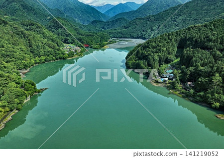 從斜角拍攝的空拍照片,展現了靜岡縣的井川湖及其周圍的青山。 從斜角拍攝的空拍照片,展現了靜岡縣的井川湖及其周圍的青山。 141219052