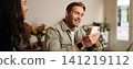 Image of handsome young man in cafe, looking at his mobile phone, using smartphone app, drinking coffee 141219112