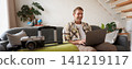 Portrait of happy young man, tourist booking his holiday with travel agency, looking at laptop, packed suitcase to go on vacation 141219117