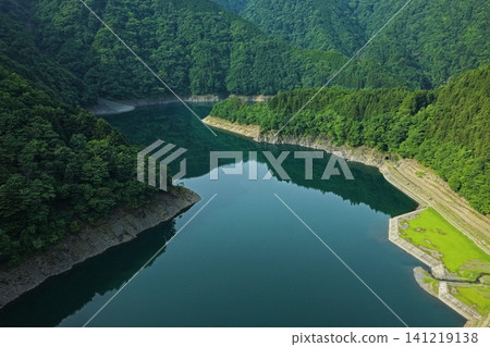 An aerial photograph overlooking Lake Sessoko in Shizuoka Prefecture, with the surrounding green mountains in the background. An aerial photograph overlooking Lake Sessoko in Shizuoka Prefecture, with the surrounding green mountains in the background. 141219138